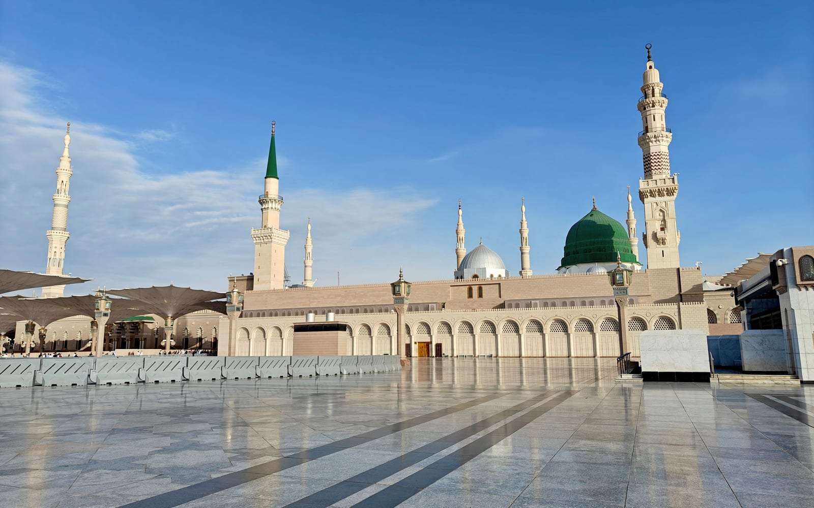ساحات المسجد النبوي ومآذنه في المدينة المنورة تحت سماء زرقاء