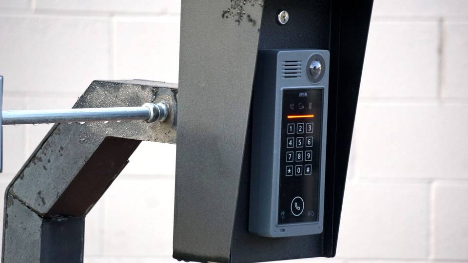 لوحة انتركم معدنية بأزرار مثبتة على عمود عند بوابة